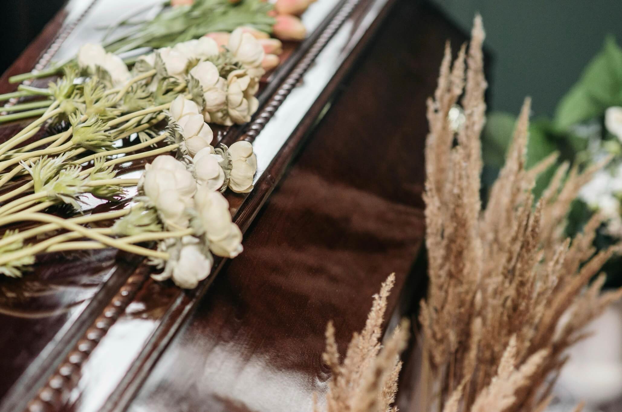 Flowers resting on a closed casket at a funeral service